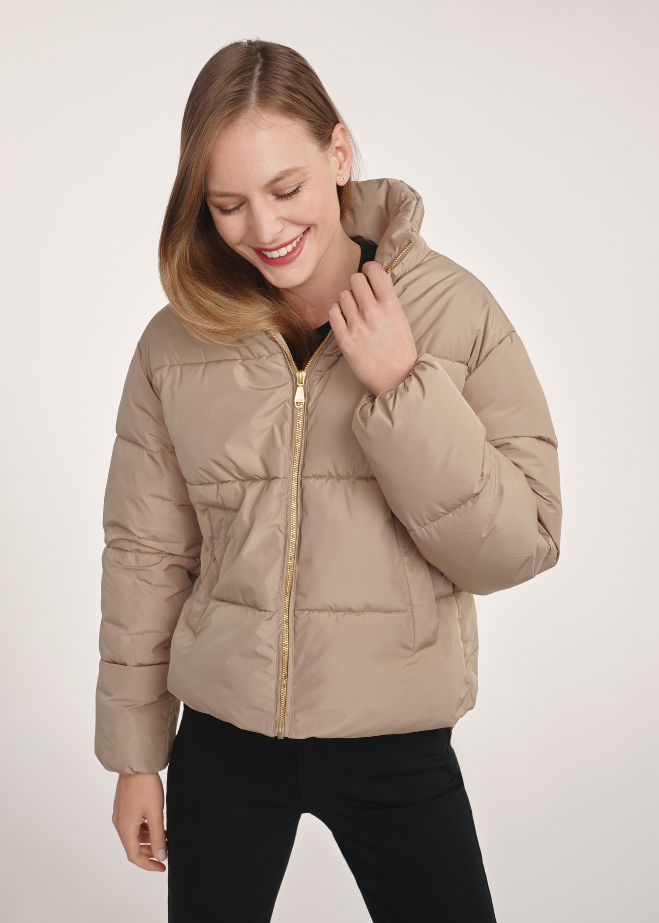 Short beige women's jacket KURDT-0601-24(Z25), front view of the product on the model. Half of the silhouette visible.