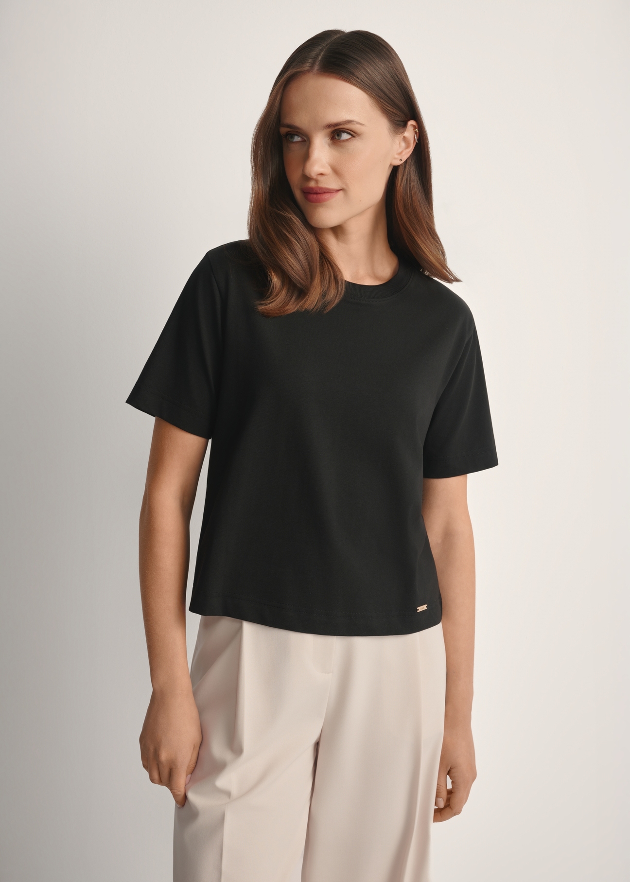 Women's cotton black T-shirt TSHDT-0138-99(W25), product view from the front on the model, half of the silhouette visible.