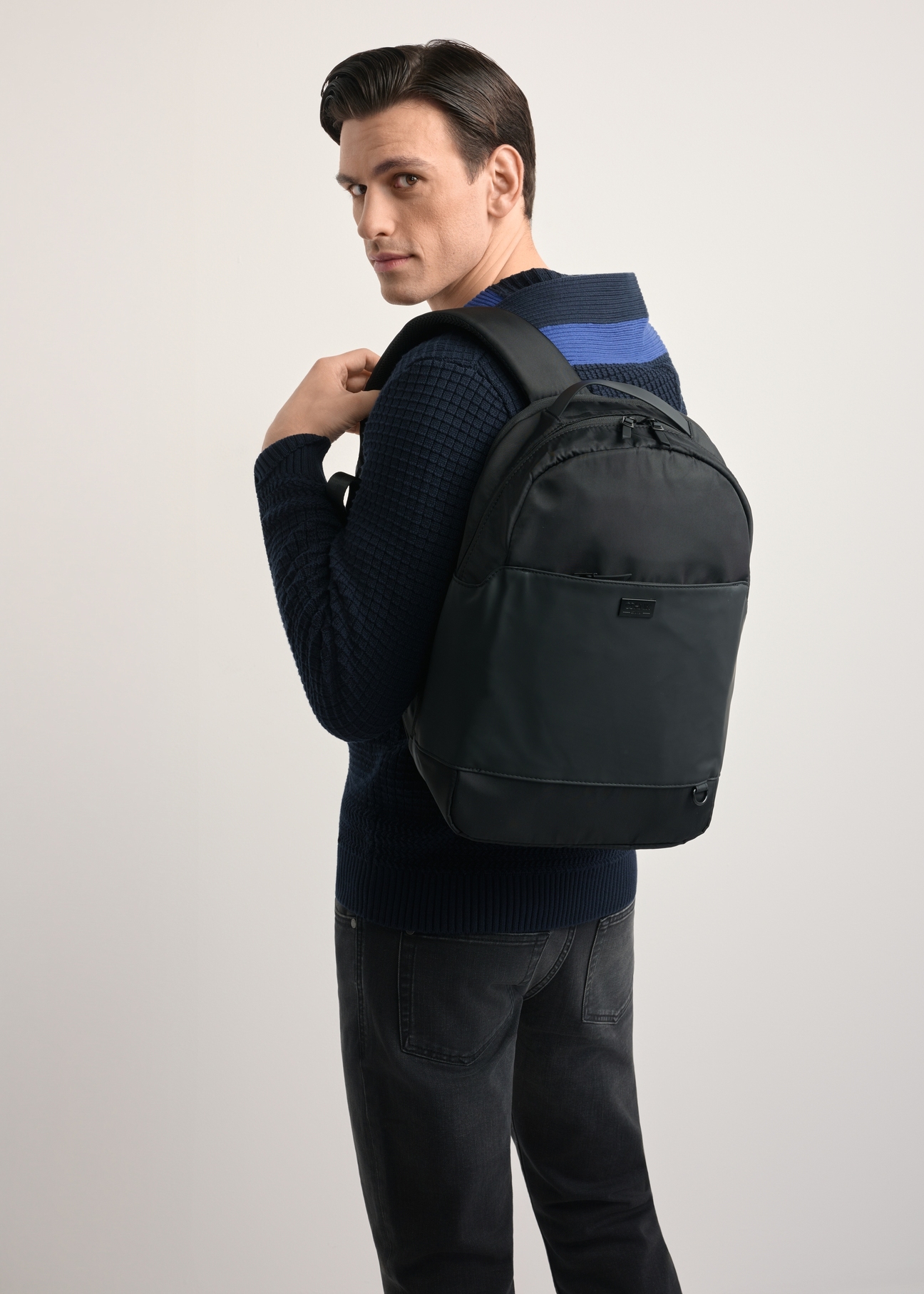 TORMN-0311B-99(Z25) Men's Two-Compartment Black Backpack - Front product view, modeled against a light background. Knee-length silhouette visible.
