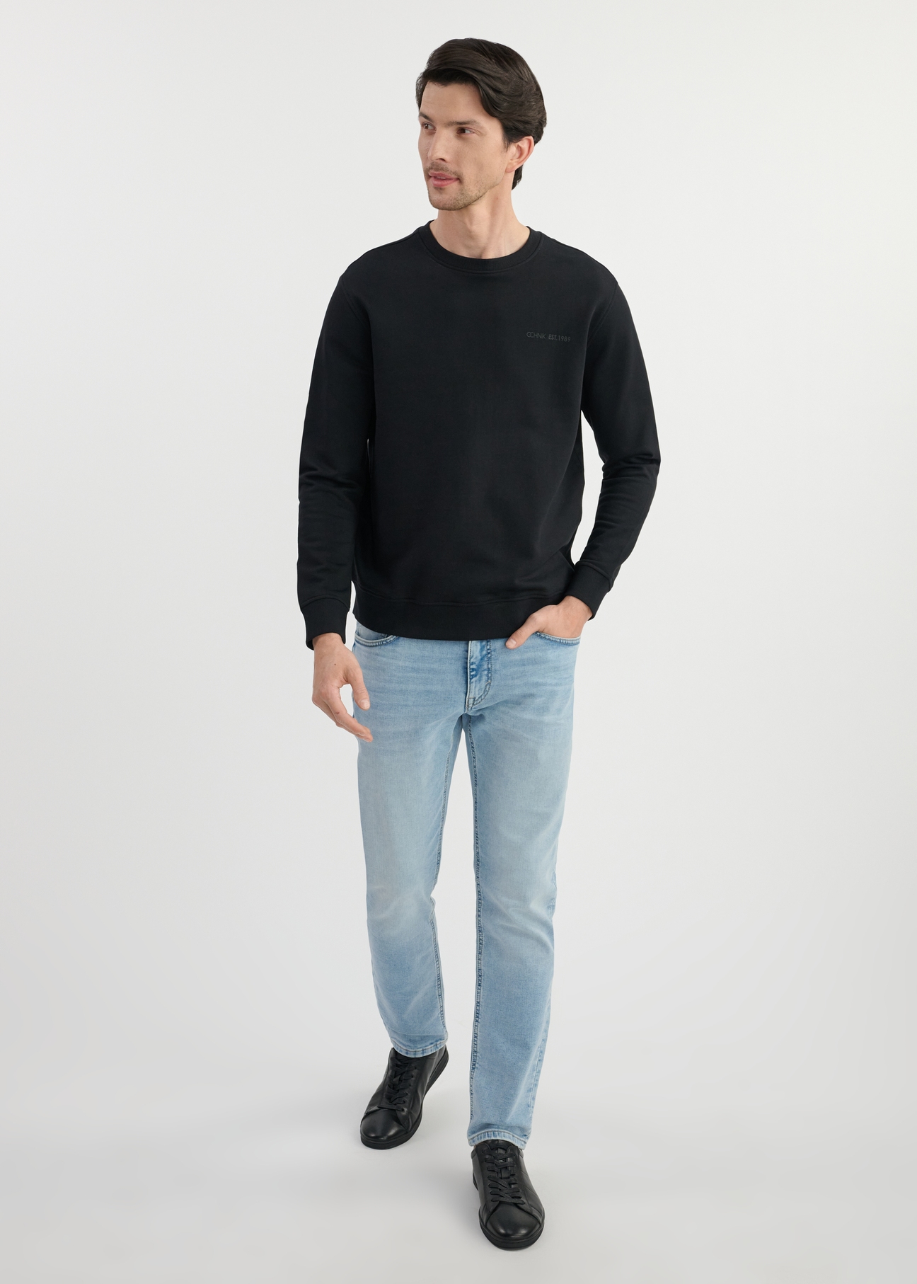 Black men's sweatshirt without hood BLZMT-0070-99(W25) - front view on the model on a white background. The entire silhouette is visible.