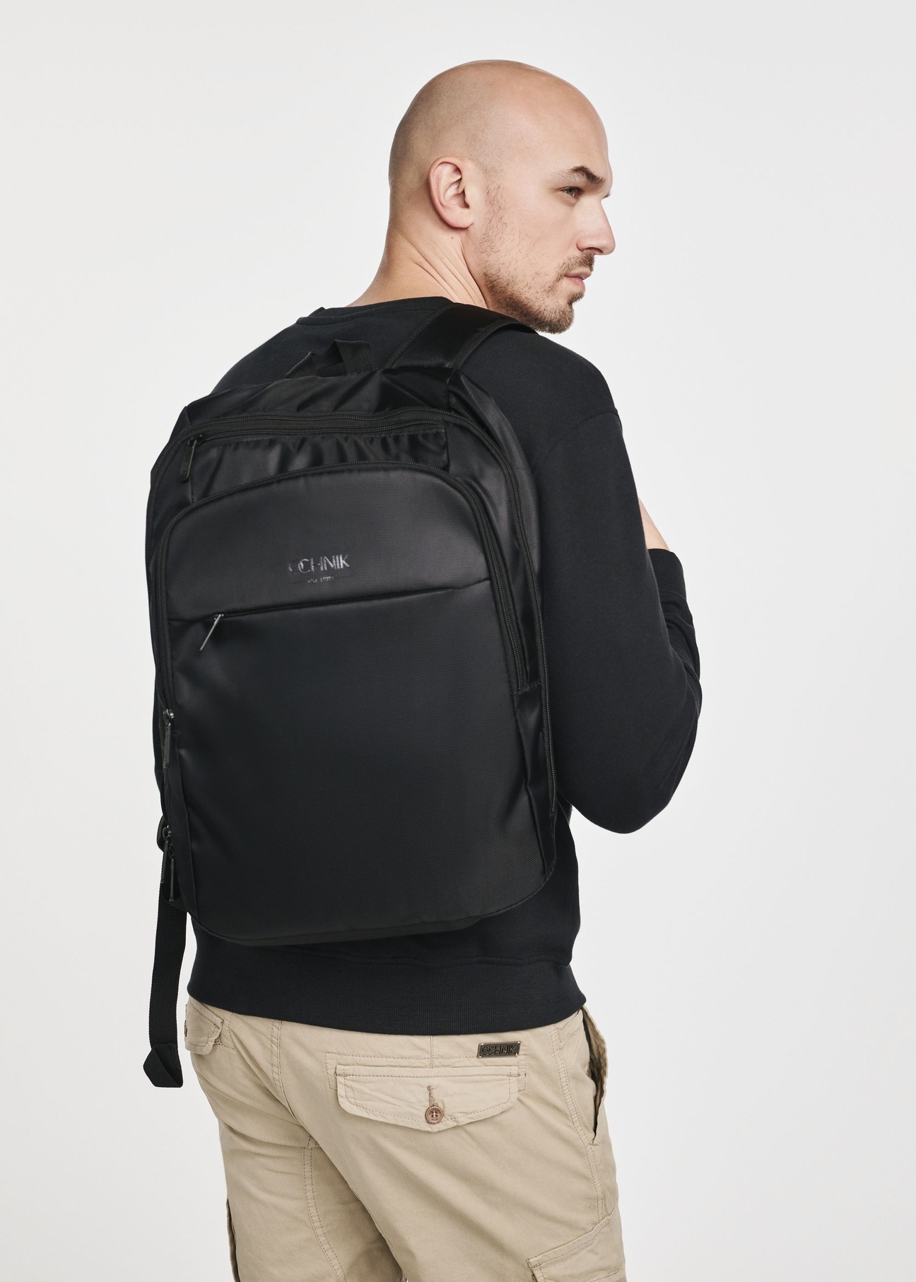 Men's black backpack with laptop compartment TORMN-0264C-99(Z25), product view on model. Half silhouette visible.