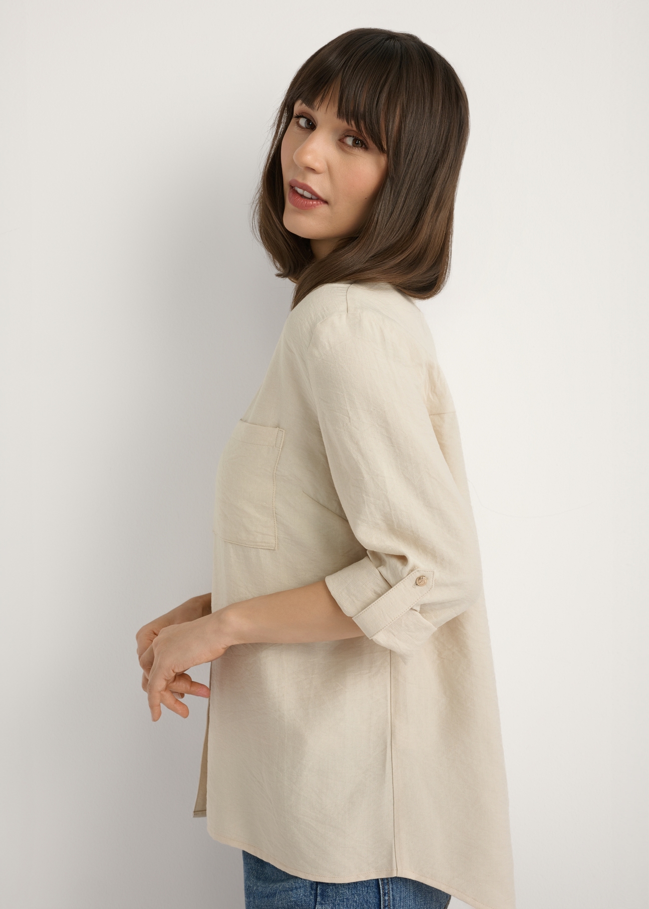 Light beige women's shirt KOSDT-0157A-1A(W26), side view of the product on the model. Half of the silhouette visible.
