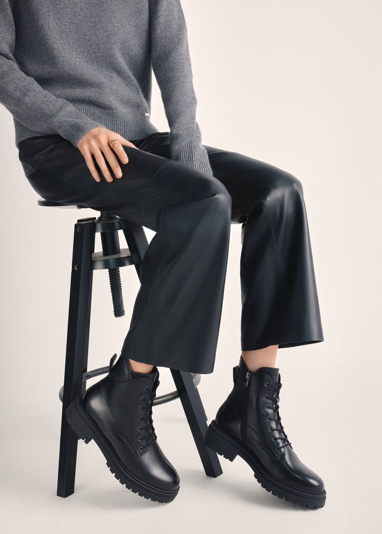 Black leather ankle boots BUTYD-1104-99(Z25), product view on model's feet against a light background.