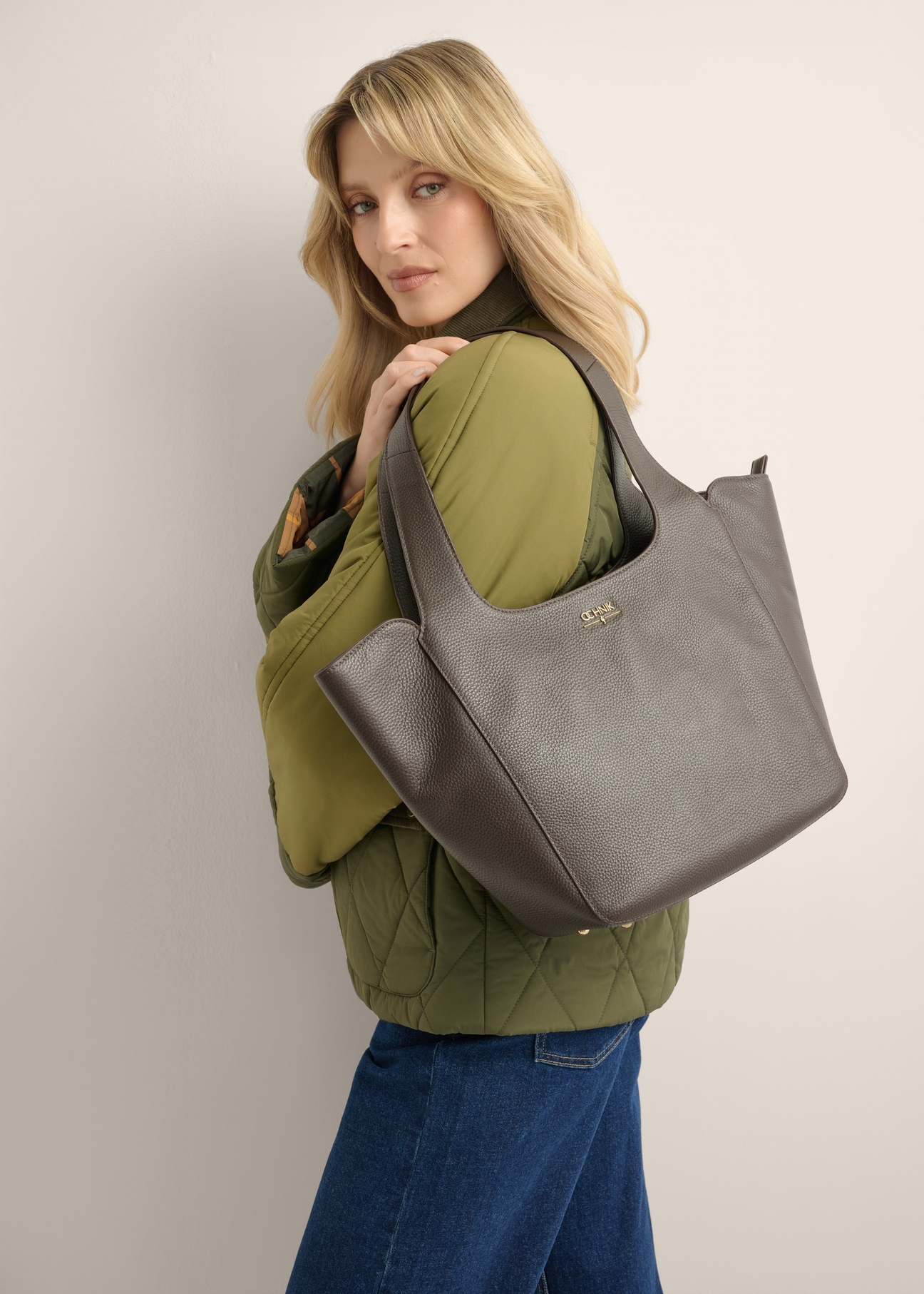 Women's dark brown leather shopper bag TORES-1340-1I(Z26), front view of the product on a model. Half of the silhouette visible.
