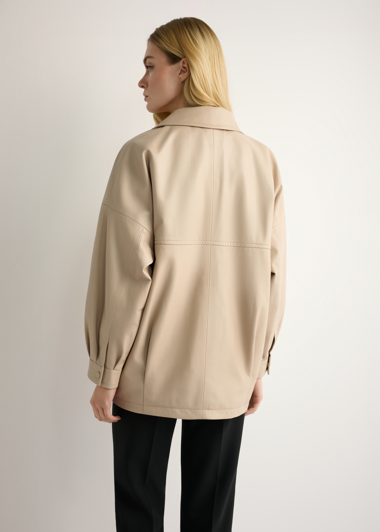 Beige oversize women's leather jacket KURDS-0577-1B(W26) - back view of the product, on a model, against a light background. Knee-length silhouette visible.