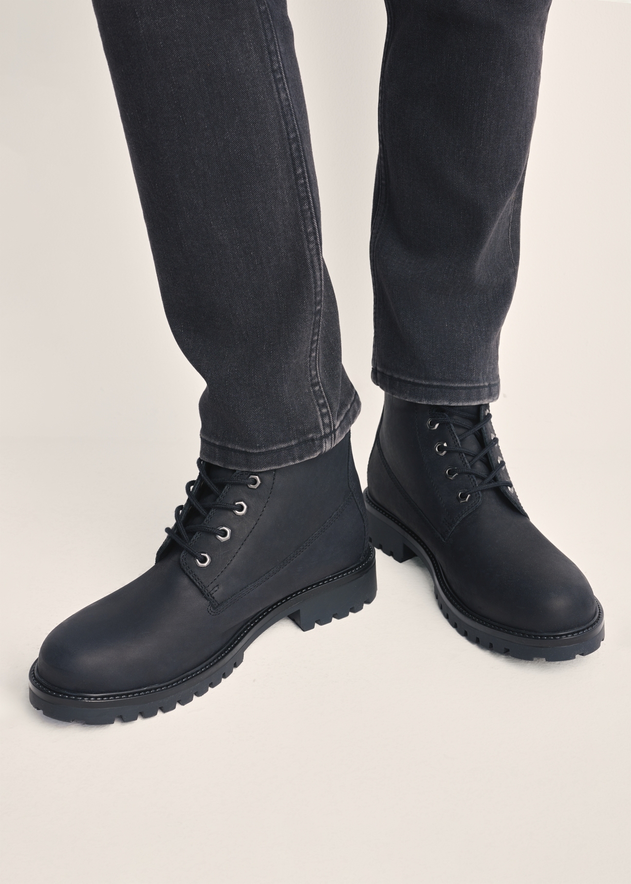 Black leather lace-up men's ankle boots BUTYM-0514-99(Z25) - front product view on model against white background. Close-up.
