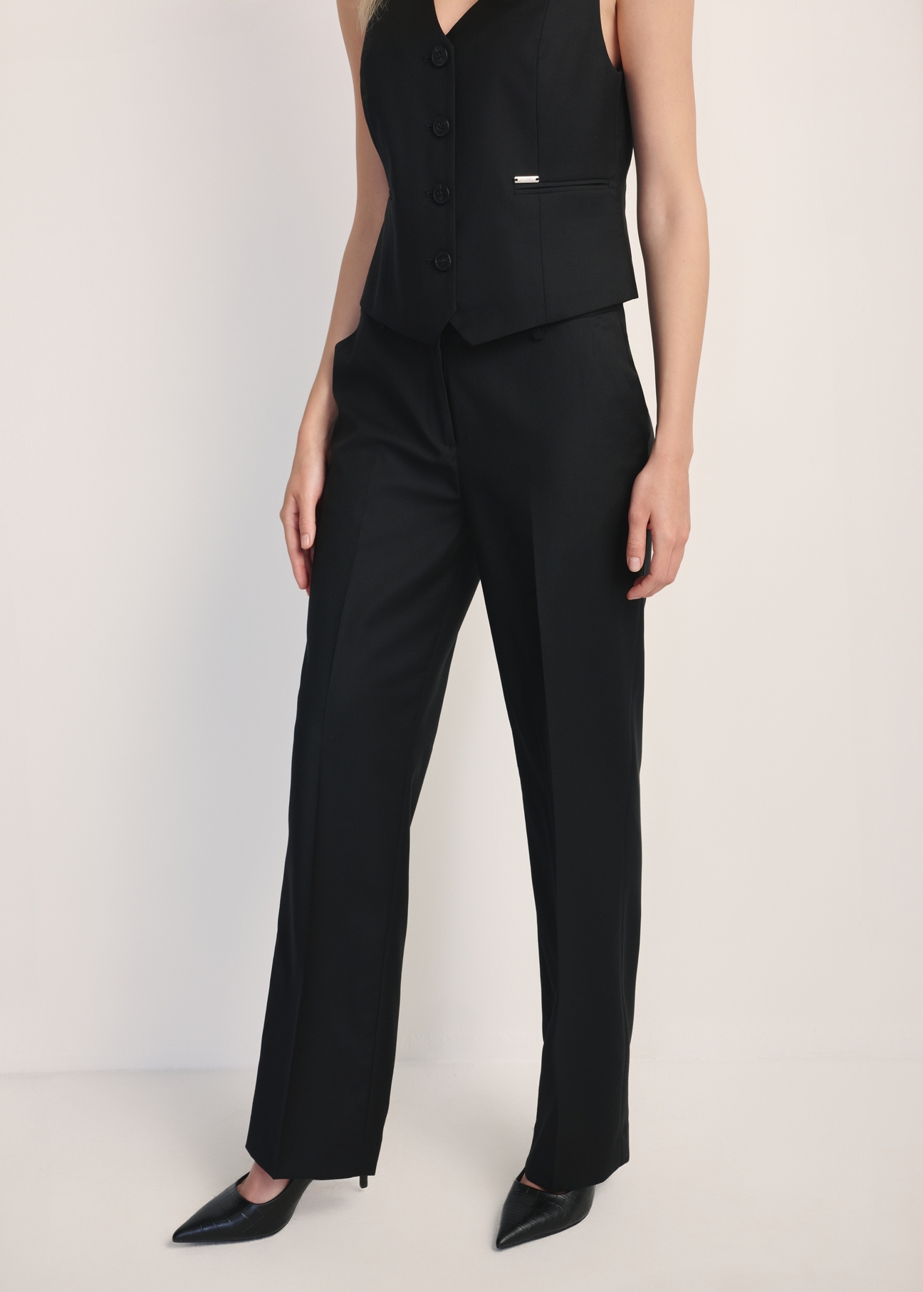 Black women's trousers with a crease SPODT-0114-99(Z25), product visible from the front on the model, half of the silhouette visible.
