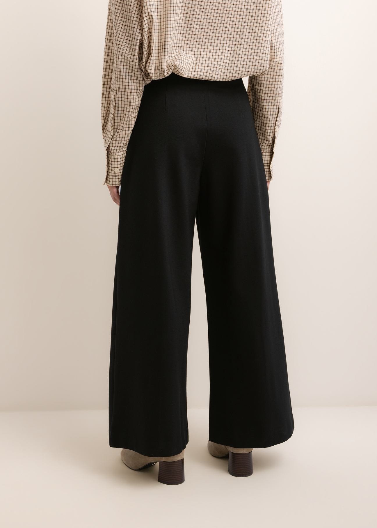 Black women's wide leg trousers SPODT-0130-99(Z26), back view of the product on the model. Half of the silhouette visible.