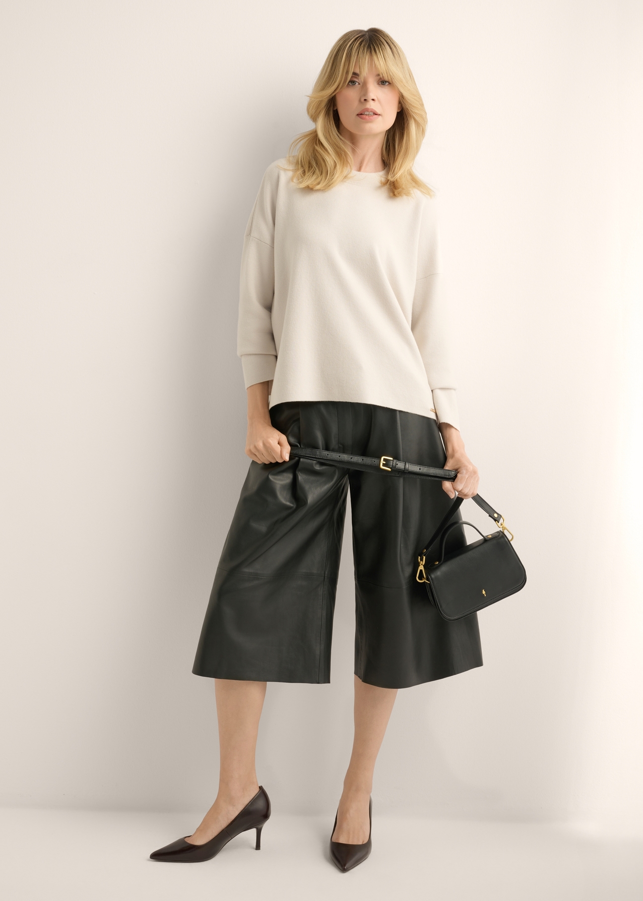 Small elegant leather women's handbag TORES-1332-99(W26), front view of the product on a model, the entire silhouette is visible.
