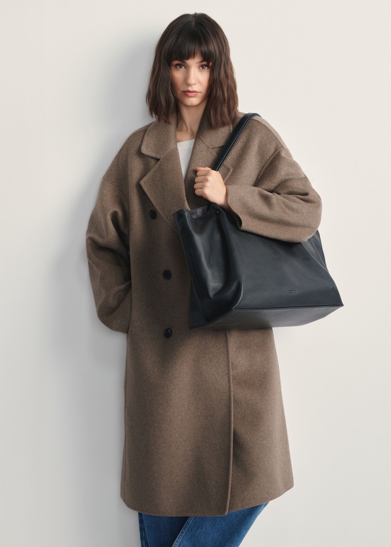 Large black leather women's handbag TORES-1181-99(Z25) - front view of the product on a model against a white background. Full body visible.