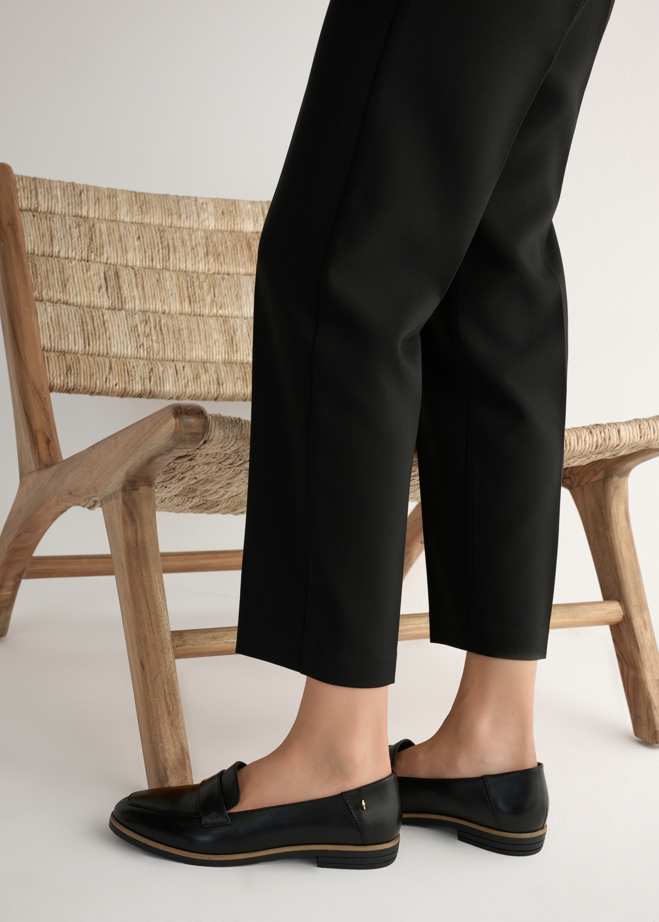 Women's black leather moccasins BUTYD-1067-99(W25), side view of the product on the model, half of the silhouette visible.