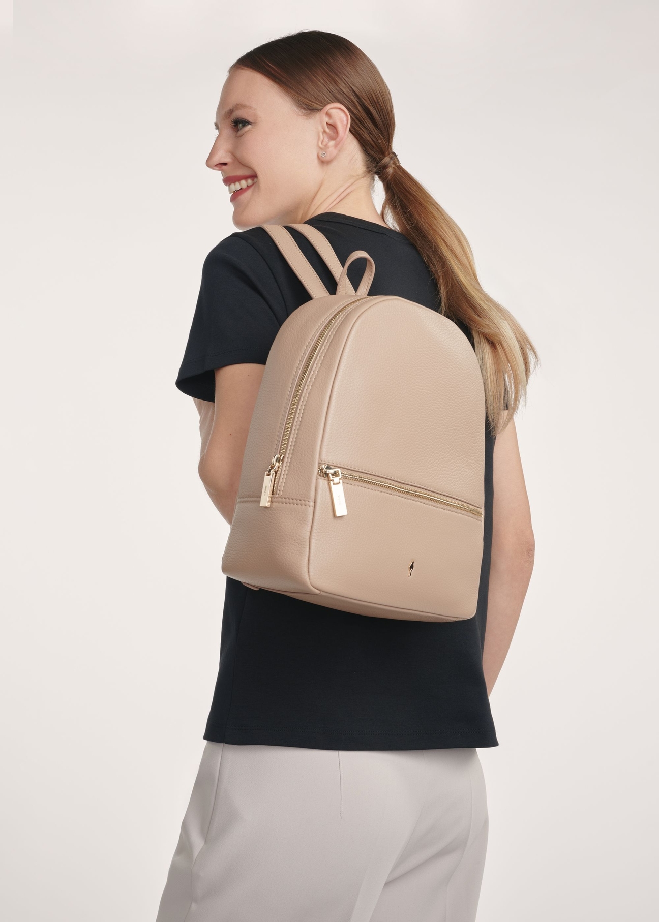 Beige leather women's backpack TORES-0898D-81(Z25), front view of the product on the model, half of the silhouette visible.