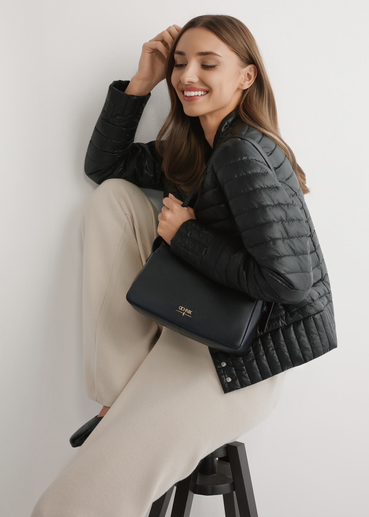 Black leather women's handbag TORES-1277-9I(W26) - front view of the product, on a model, against a light background. Half-length silhouette visible.