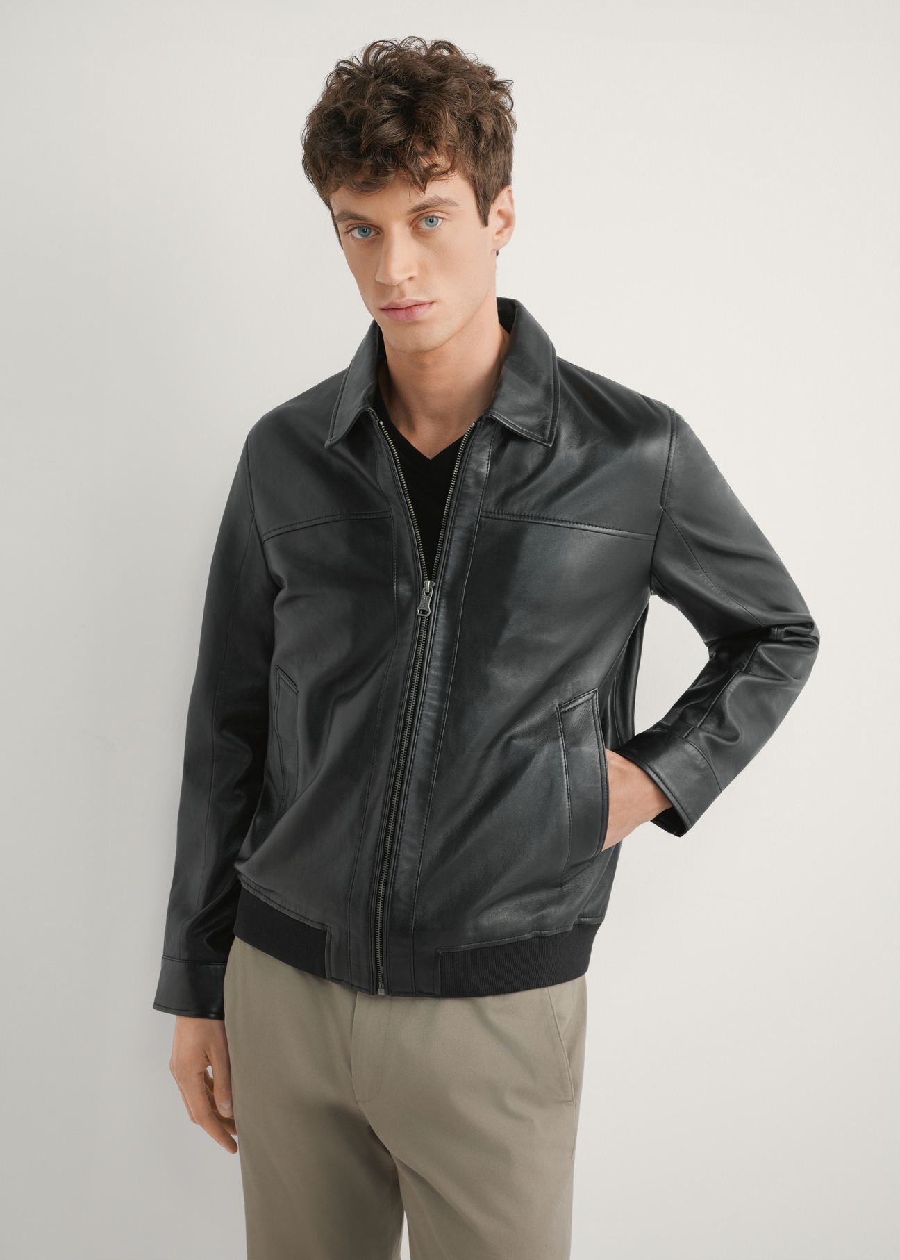 Black men's leather jacket KURMS-0407-99(W26), front product view on model. Half silhouette visible.