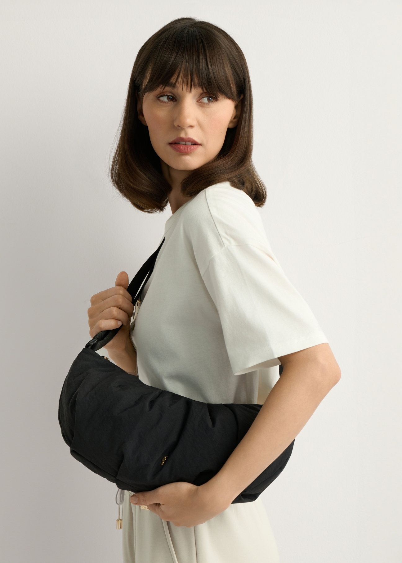 Women's nylon handbag TOREN-0339-99(W26), product view on model's shoulder. Half of silhouette visible.