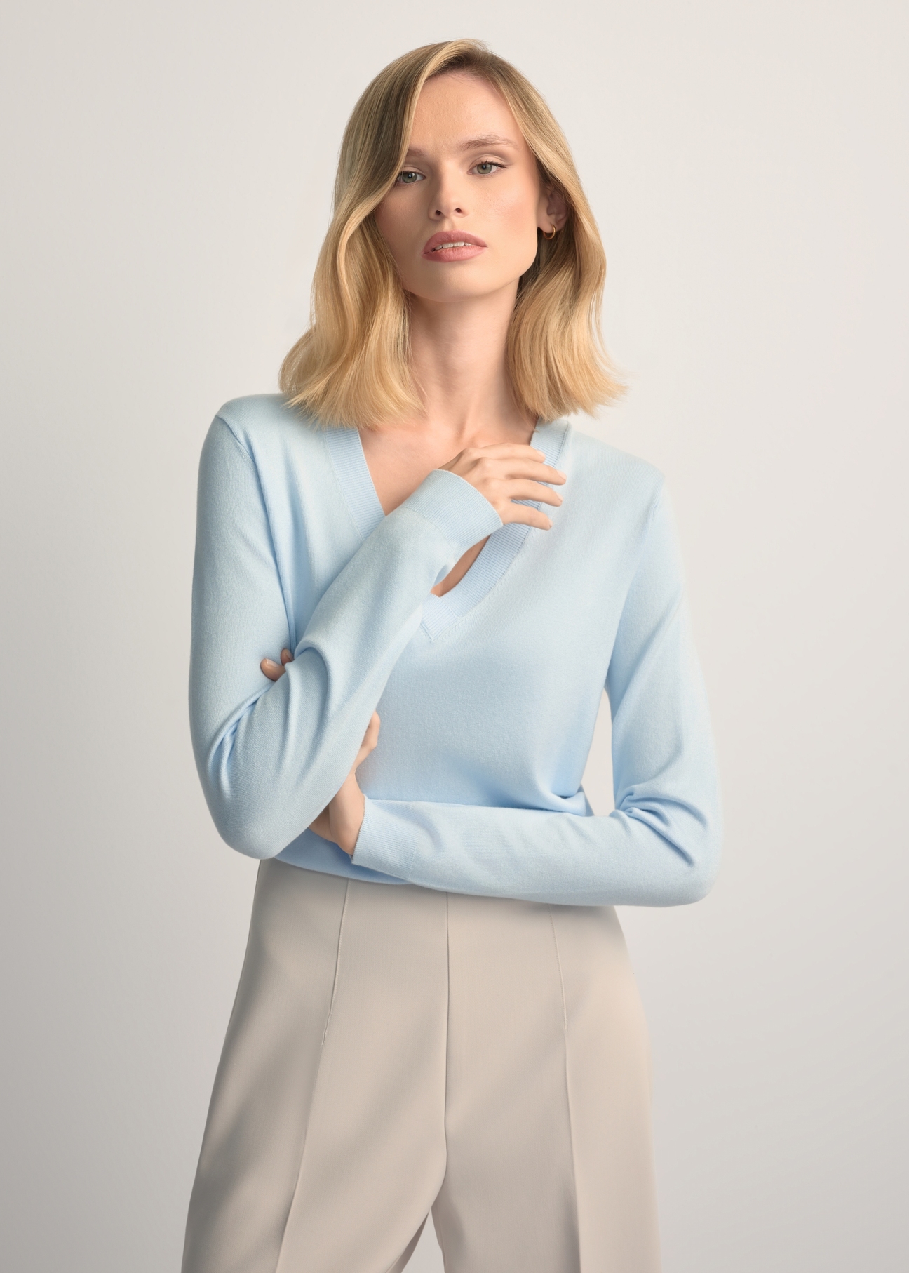 Light blue V-neck sweater SWEDT-0201-7A(W26) - front view of the product, on a model, against a light background. Half of the silhouette visible.