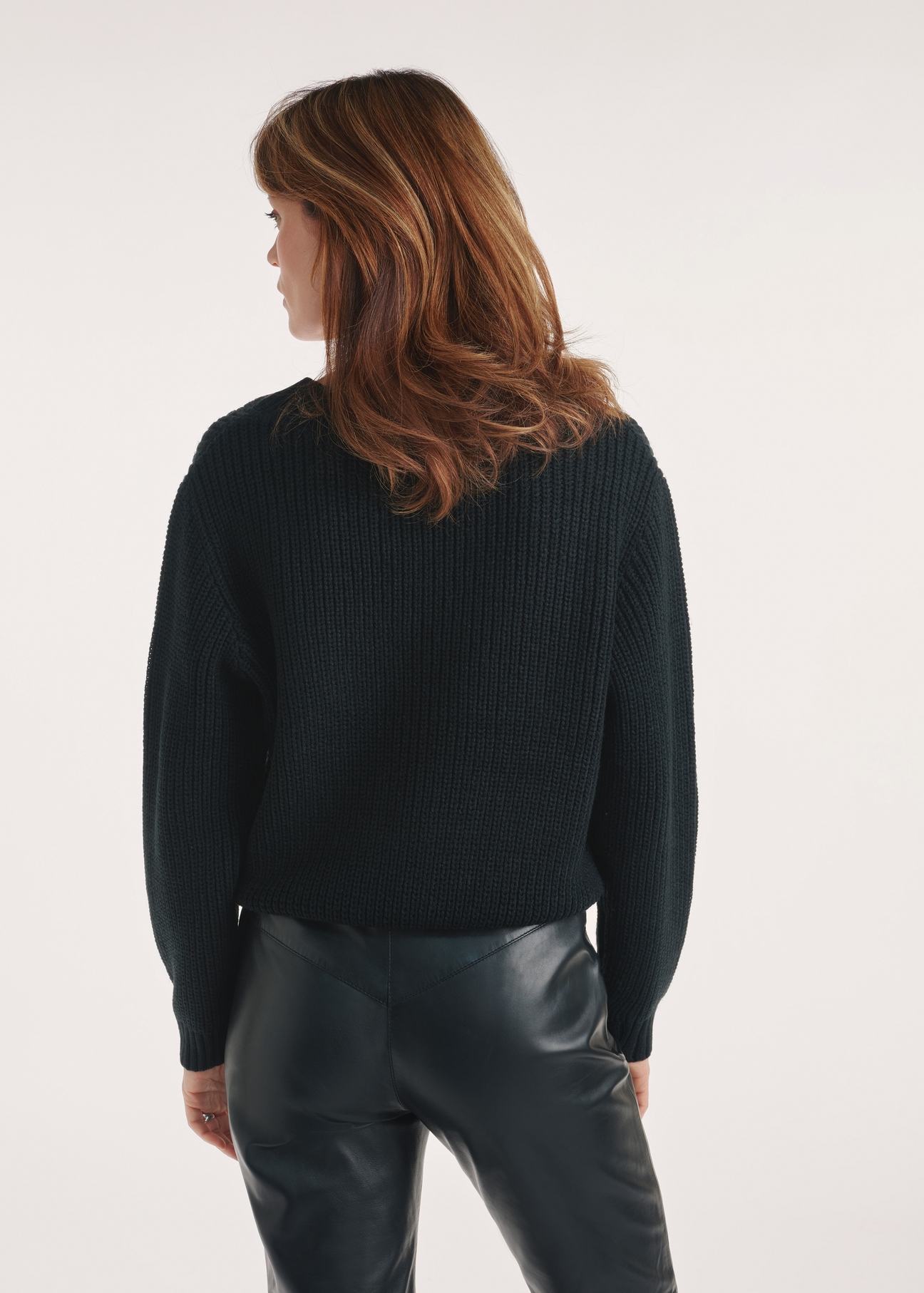 Black women's V-neck sweater SWEDT-0162-99(Z24), view of the product from the back on the model, half of the silhouette visible.