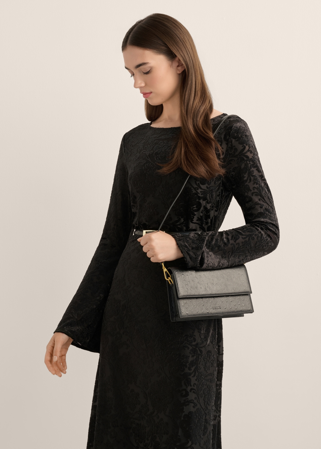 Women's black messenger bag TORES-1390-9P(Z26), diagonal view of the product on the model. Half of the silhouette visible.