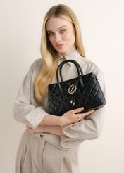 Quilted black women's handbag TOREC-1312-99(Z26), front view of the product on a model. Half-body shot.