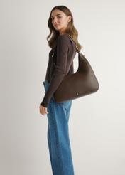 Brown women's shopper bag TOREC-1238-1I(W26), product view on model's shoulder. Half of silhouette visible.
