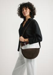 Dark brown leather semi-circular handbag TORES-1309-1I(W26), product view on model's shoulder. Half of silhouette visible.