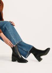 Black leather high-heeled ankle boots BUTYD-1101-99(Z25), product view on model's feet against a light background.