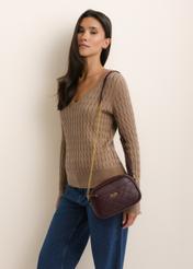 Burgundy small women's handbag TOREC-1285-4P(Z26), front view of the product, on a model, on a light background. Half of the silhouette visible.