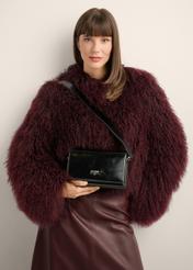 Black elegant leather women's handbag TORES-1356-9F(Z26), view of the product in the model's hand, on a light background.