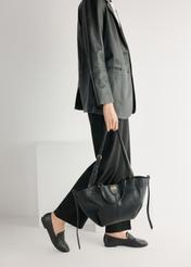 Women's black leather moccasins BUTYD-1074A-99(W26), product view from the front on the model, half of the silhouette visible.