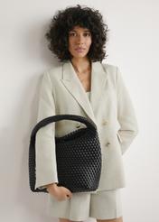 Black woven shopper bag TOREC-1148-99(W26) - view of the product held in the model's hand against a light background. Half of the silhouette is visible.