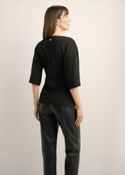 Black women's blouse with draping TSHDT-0163-99(Z26), product view from the back on the model, half of the silhouette visible.