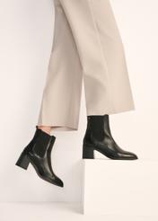 Women's black leather high-heeled Chelsea boots BUTYD-1185-99(Z25) - front view of the product on a model against a white background. Half of the silhouette visible.