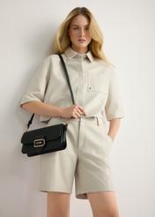 Black women's messenger bag TOREC-1120-99(W26) - product view slightly diagonal, on a model, against a light background. Knee-length silhouette visible.