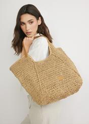 Beige straw shopper bag TOREC-1223-1E(W26) - front view of the product, on a model, on a light background.