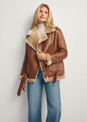 Brown short women's sheepskin coat KOZDP-0001A-89(Z25), front view of the product on the model, half of the silhouette visible.