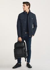 Black spacious men's backpack PLCMS-0022-99(Z25), front view of the product on the model, half of the silhouette visible.