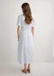 Long floral dress in white SUKDT-0191-7P(W26), back view of the product on the model. Full body visible.