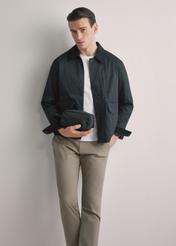 Black men's cosmetic bag TORMN-0352-99(W26), front view of the product in the model's hand. Half of the silhouette visible.