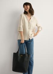 Large black women's shopper handbag TOREC-1142-9I(W26), view of the product in the model's hand. Full body visible.