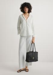 Dark brown woven women's handbag TORES-1301-1I(W26), product view in model's hand. Full body visible.