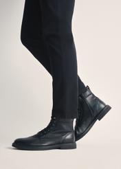 Black men's leather ankle boots BUTYM-0516-99(Z25), product view on model's feet against a light background.
