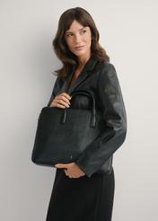 Black leather laptop bag TORES-1070A-99(W26), product view in model's hands. Half silhouette visible.