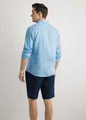 Modrá pánska ľanová košeľa KOSMT-0321A-7B(W26), pohľad zozadu na výrobok, na modelke, na svetlom pozadí. Viditeľná polovica siluety.