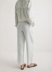 Light beige linen women's trousers SPODT-0124-1A(W26), product view from the back on the model, half of the silhouette visible.
