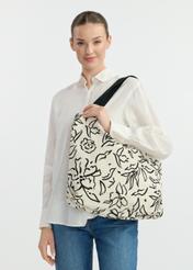 Women's fabric handbag with flowers TOREN-0289A-98(W25), view of the diagonal of the product on the model's shoulder. Half of the silhouette visible.