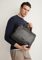 Black leather two-compartment men's bag TORMS-0525-99(Z26), product view in model's hands. Half of silhouette visible.