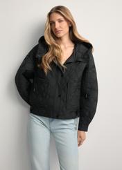 Black KURDT-0660-99(W26) short oversize quilted jacket - front view of the product, on a model, against a light background. Knee-length silhouette visible.
