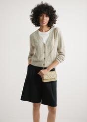 Small beige leather women's handbag TORES-1044-1B(W26) - front view of the product, on a model, against a light background. Half-length silhouette visible.