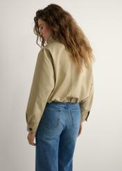 Beige women's short jacket KURDT-0657-1B(W26) - back view of the product on a model, against a light background. Knee-length silhouette visible.