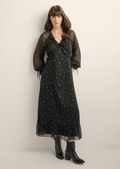 Black maxi dress with a lilac pattern and ruffles SUKDT-0290-9P(Z26), product view from the front on the model. Full body visible.